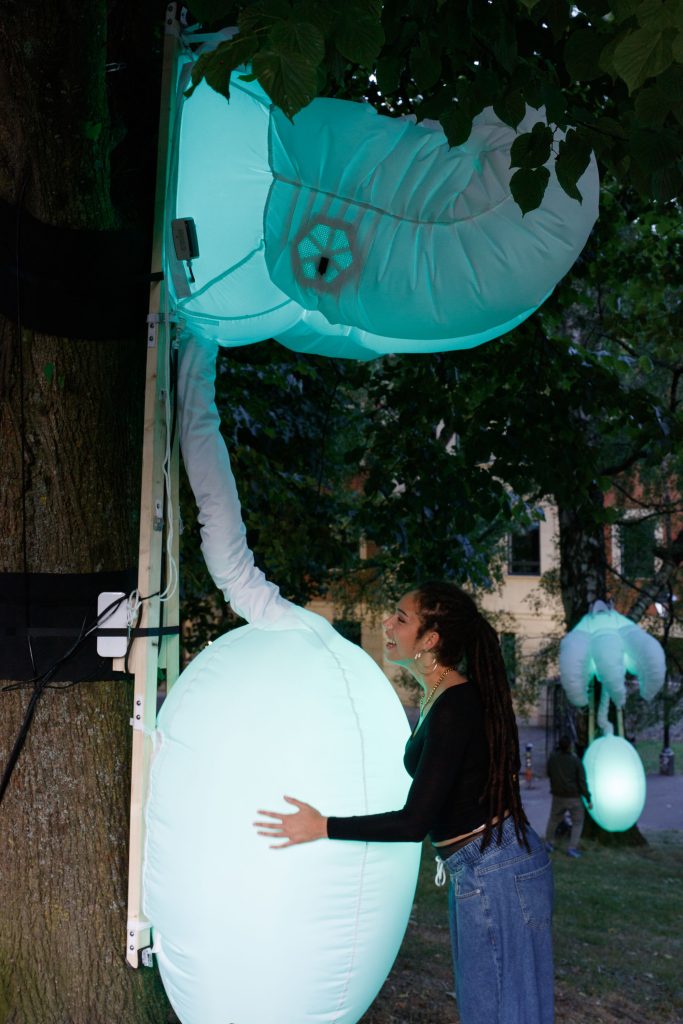 A women squeezing a blue inflatable creature.